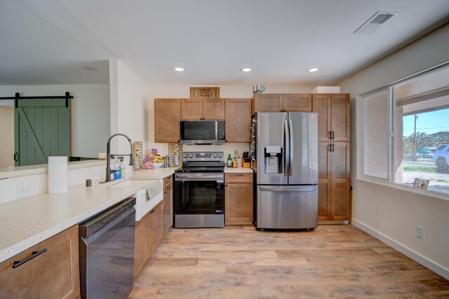 kitchen with a sink, light countertops, stainless steel appliances, and visible vents