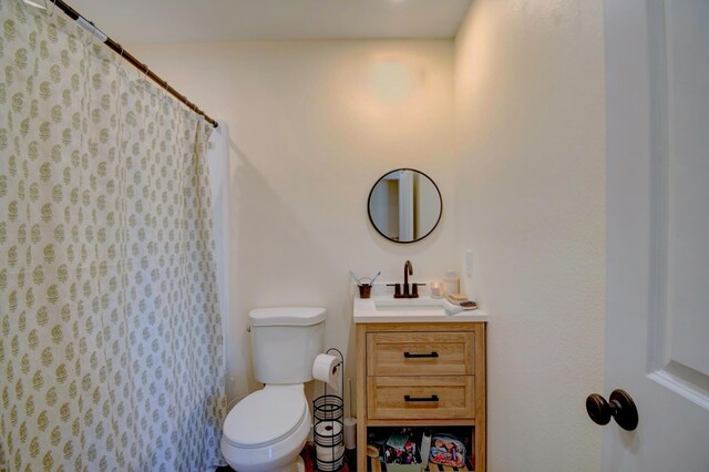 bathroom with toilet, a shower with curtain, and vanity