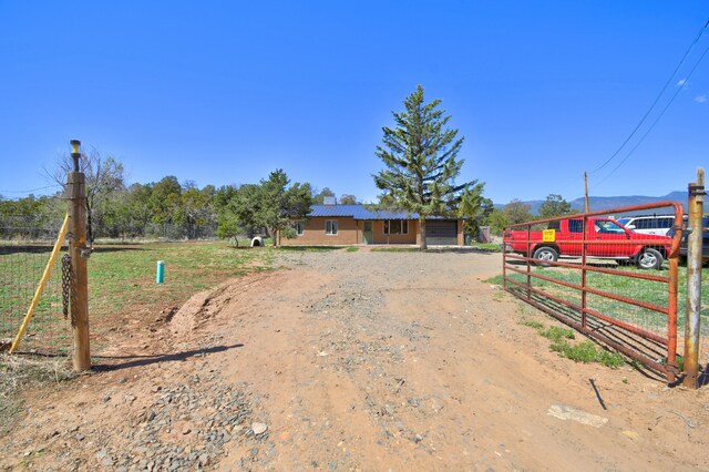 view of yard featuring fence and dirt driveway