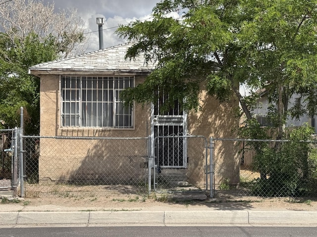 view of front of property featuring a gate, a fenced front yard, and stucco siding