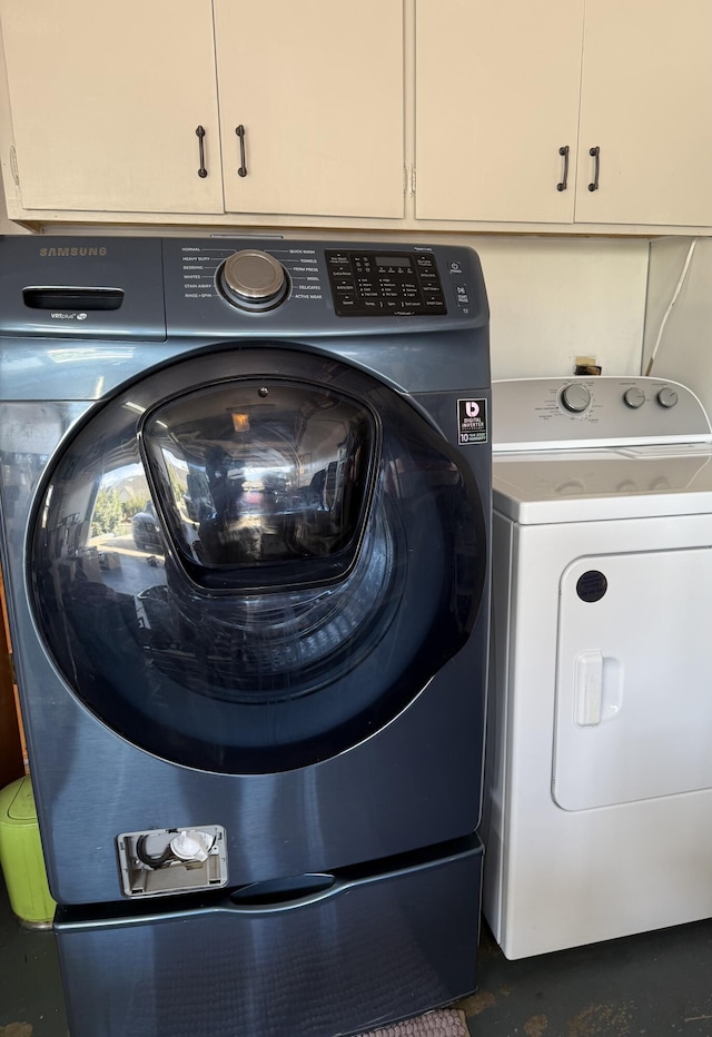 clothes washing area with cabinet space and separate washer and dryer