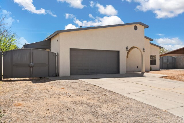 5812 Alegria Rd NW, Albuquerque, NM 87114 - view of side of home featuring a gate, an attached garage, and concrete driveway