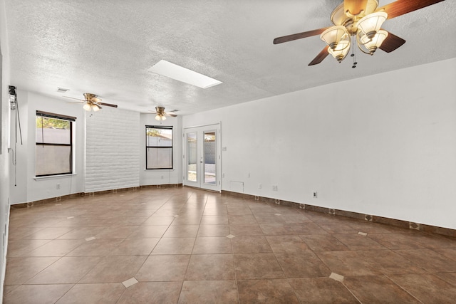 5812 Alegria Rd NW, Albuquerque, NM 87114 - tiled spare room with a skylight, a ceiling fan, a textured ceiling, and visible vents