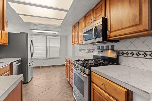 5812 Alegria Rd NW, Albuquerque, NM 87114 - kitchen featuring light countertops, stainless steel appliances, a textured ceiling, and tasteful backsplash