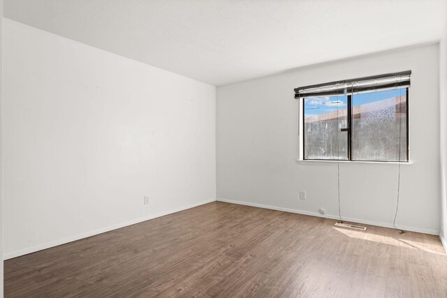 5812 Alegria Rd NW, Albuquerque, NM 87114 - unfurnished room with baseboards, wood finished floors, and visible vents