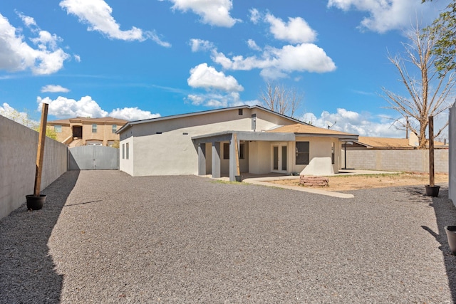 5812 Alegria Rd NW, Albuquerque, NM 87114 - back of house featuring a patio, a gate, a fenced backyard, and stucco siding