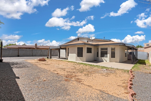 5812 Alegria Rd NW, Albuquerque, NM 87114 - back of house with a fenced backyard, a patio, stucco siding, and an outdoor fire pit