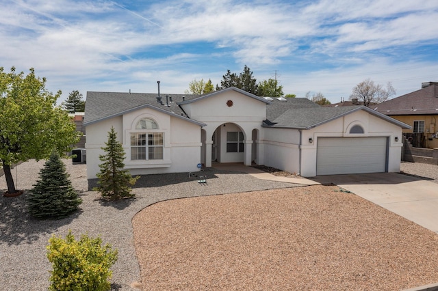 view of front of home with a garage, stucco siding, driveway, and roof with shingles