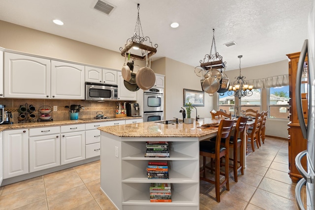 3809 Bay Hill Loop SE, Rio Rancho, NM 87124 - kitchen with light tile patterned flooring, a notable chandelier, a sink, stainless steel appliances, and visible vents