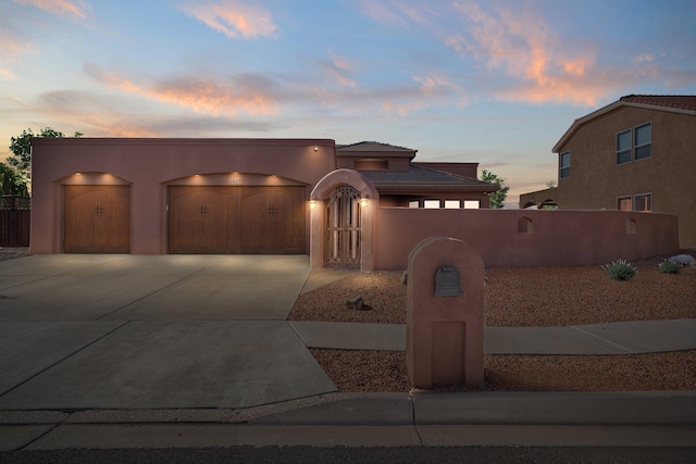 3809 Bay Hill Loop SE, Rio Rancho, NM 87124 - pueblo revival-style home featuring a fenced front yard, a tile roof, concrete driveway, an attached garage, and stucco siding