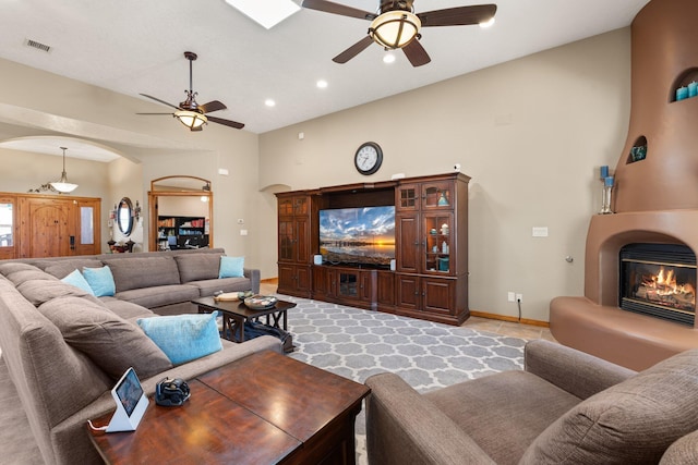 3809 Bay Hill Loop SE, Rio Rancho, NM 87124 - living room featuring arched walkways, a large fireplace, a ceiling fan, baseboards, and visible vents