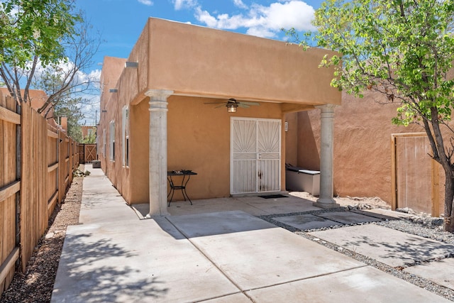 back of house featuring a ceiling fan, a fenced backyard, a patio area, and stucco siding
