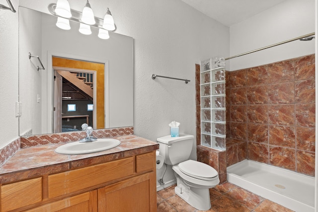full bathroom featuring a textured wall, tile patterned flooring, vanity, toilet, and tiled shower