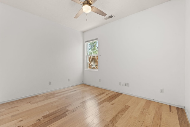 spare room featuring ceiling fan, visible vents, baseboards, and light wood-type flooring