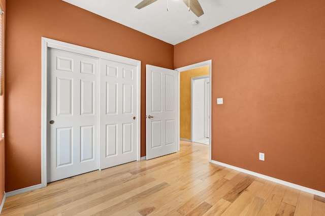 unfurnished bedroom with light wood-type flooring, baseboards, ceiling fan, and a closet