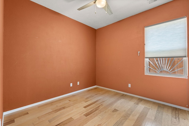 empty room featuring a ceiling fan, baseboards, and light wood-type flooring