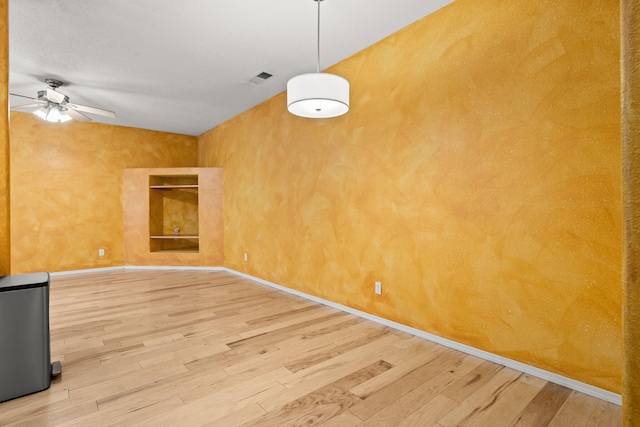 unfurnished room featuring visible vents, a ceiling fan, baseboards, and wood finished floors