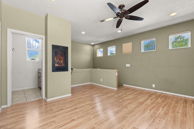 interior space with baseboards, recessed lighting, a ceiling fan, and light wood-style flooring