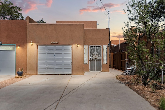 contemporary house with stucco siding, fence, and driveway