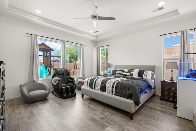 bedroom featuring visible vents, wood finished floors, and a raised ceiling
