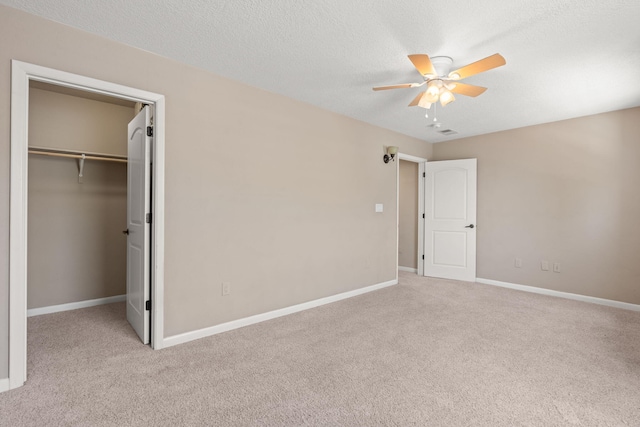unfurnished bedroom featuring baseboards, ceiling fan, carpet, and a spacious closet