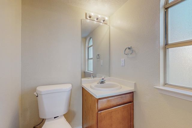 bathroom featuring plenty of natural light, toilet, and vanity
