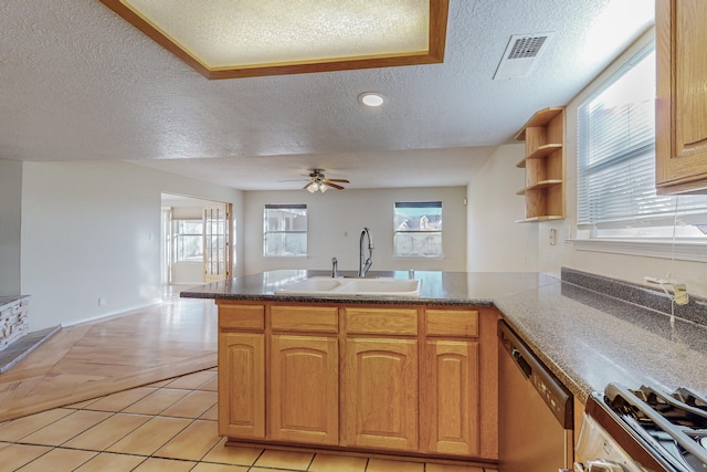 kitchen featuring a sink, dishwasher, a textured ceiling, a peninsula, and a ceiling fan
