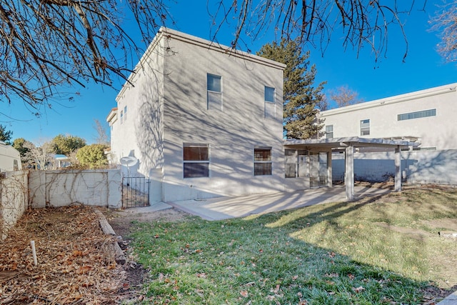 rear view of house with a pergola, a patio, a fenced backyard, a gate, and a lawn