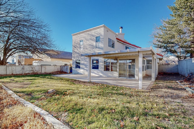 rear view of house featuring a patio, a fenced backyard, a lawn, and stucco siding