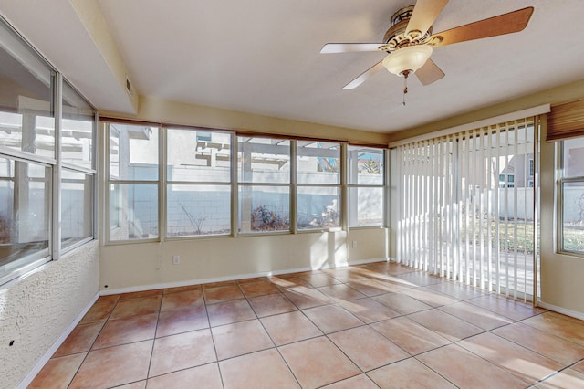 unfurnished sunroom featuring baseboards and tile patterned flooring