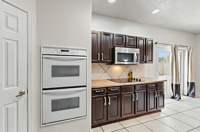 4954 Dream Dancer Dr NE, Rio Rancho, NM 87144 - kitchen with decorative backsplash, white double oven, light countertops, stainless steel microwave, and black electric stovetop