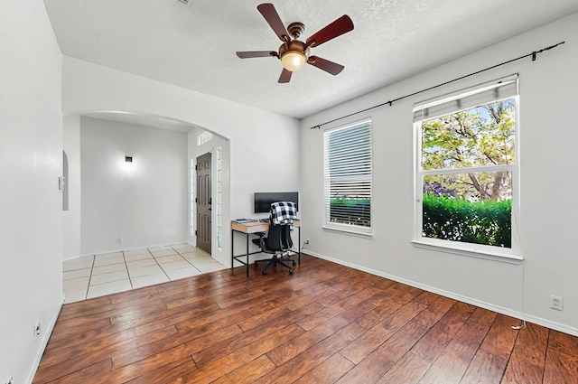 4954 Dream Dancer Dr NE, Rio Rancho, NM 87144 - office space with wood finished floors, baseboards, ceiling fan, a textured ceiling, and arched walkways