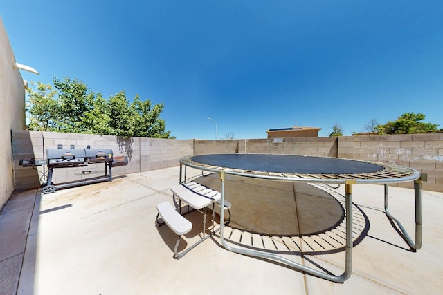 4954 Dream Dancer Dr NE, Rio Rancho, NM 87144 - view of patio with a fenced backyard and a trampoline