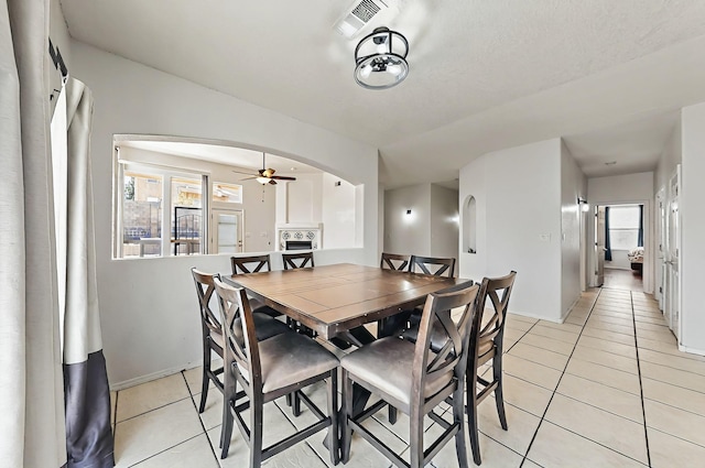 4954 Dream Dancer Dr NE, Rio Rancho, NM 87144 - dining area with visible vents, a ceiling fan, light tile patterned flooring, baseboards, and arched walkways
