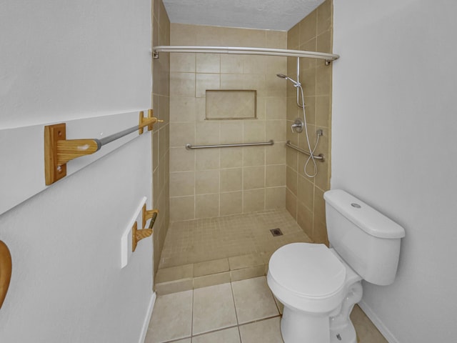 full bath with toilet, baseboards, tiled shower, and tile patterned flooring