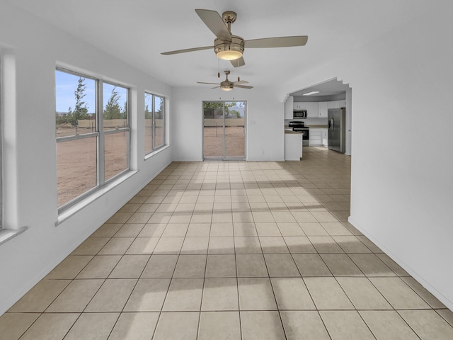 interior space with light tile patterned flooring and ceiling fan