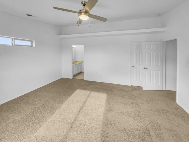 empty room featuring ceiling fan, light carpet, and visible vents