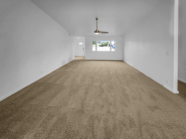 carpeted spare room featuring baseboards and a ceiling fan