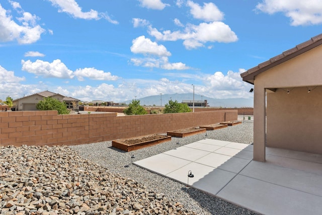view of patio / terrace with a garden, a mountain view, and fence