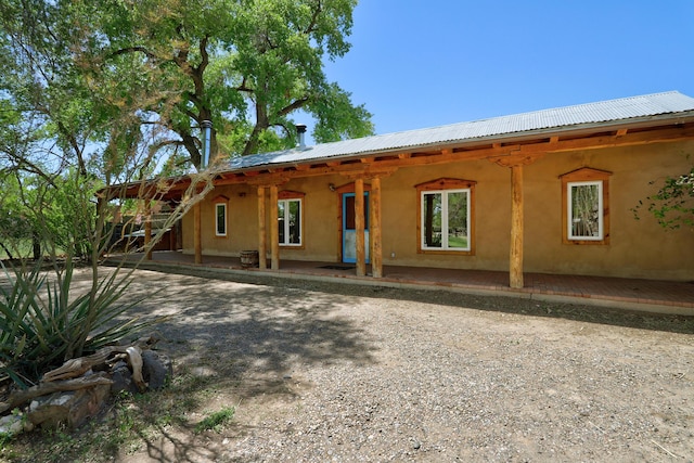 545 Atrisco Dr NW, Albuquerque, NM 87105 - rear view of house with stucco siding, a patio area, and metal roof