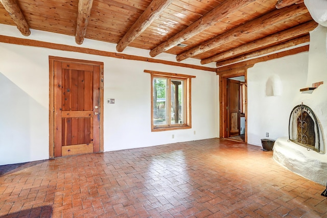 545 Atrisco Dr NW, Albuquerque, NM 87105 - unfurnished living room featuring wood ceiling, brick floor, and beamed ceiling