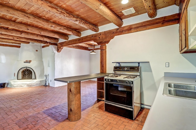 545 Atrisco Dr NW, Albuquerque, NM 87105 - kitchen with gas range, a sink, wooden ceiling, beamed ceiling, and brick floor