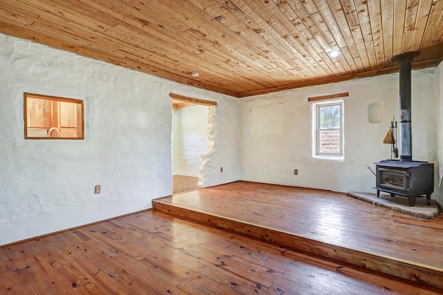545 Atrisco Dr NW, Albuquerque, NM 87105 - unfurnished living room featuring wooden ceiling, a wood stove, and hardwood / wood-style floors