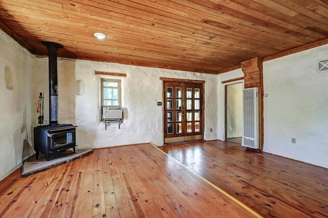 545 Atrisco Dr NW, Albuquerque, NM 87105 - unfurnished living room featuring a wood stove, hardwood / wood-style flooring, wooden ceiling, cooling unit, and a heating unit