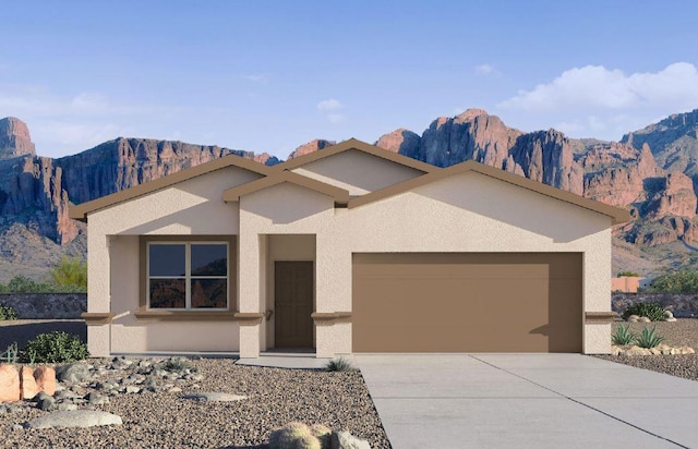 view of front facade with a garage, a mountain view, stucco siding, and driveway