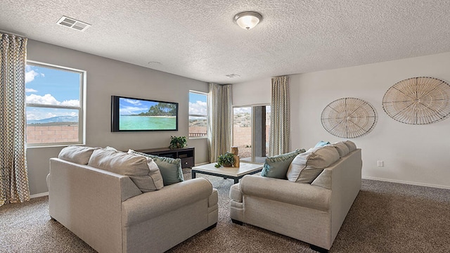 carpeted living area featuring baseboards, a textured ceiling, and visible vents