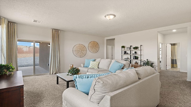 carpeted living area with visible vents and a textured ceiling