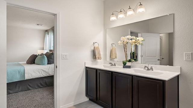 bathroom with a sink, ensuite bath, double vanity, and visible vents