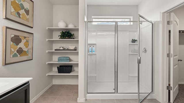 full bath with vanity, baseboards, and a stall shower