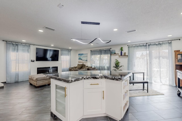 7218 Whippoorwill Ln NE, Albuquerque, NM 87109 - kitchen featuring visible vents, white cabinets, open floor plan, dark stone counters, and recessed lighting